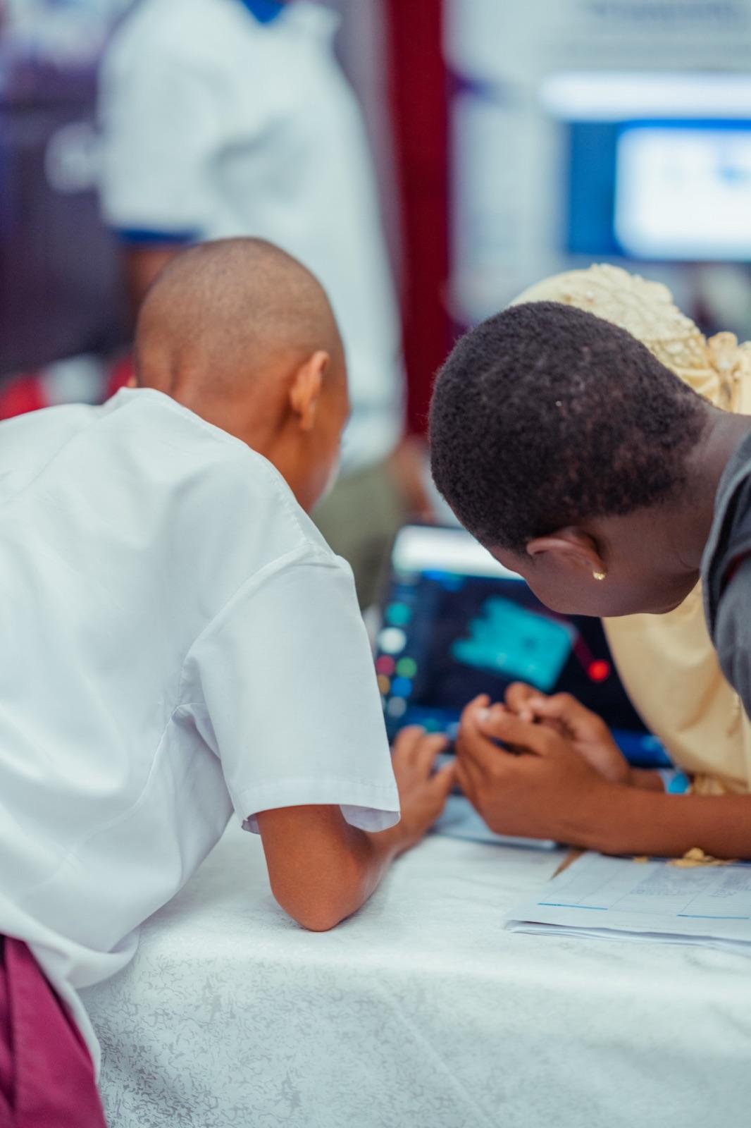 Two young learners coding together on a tablet