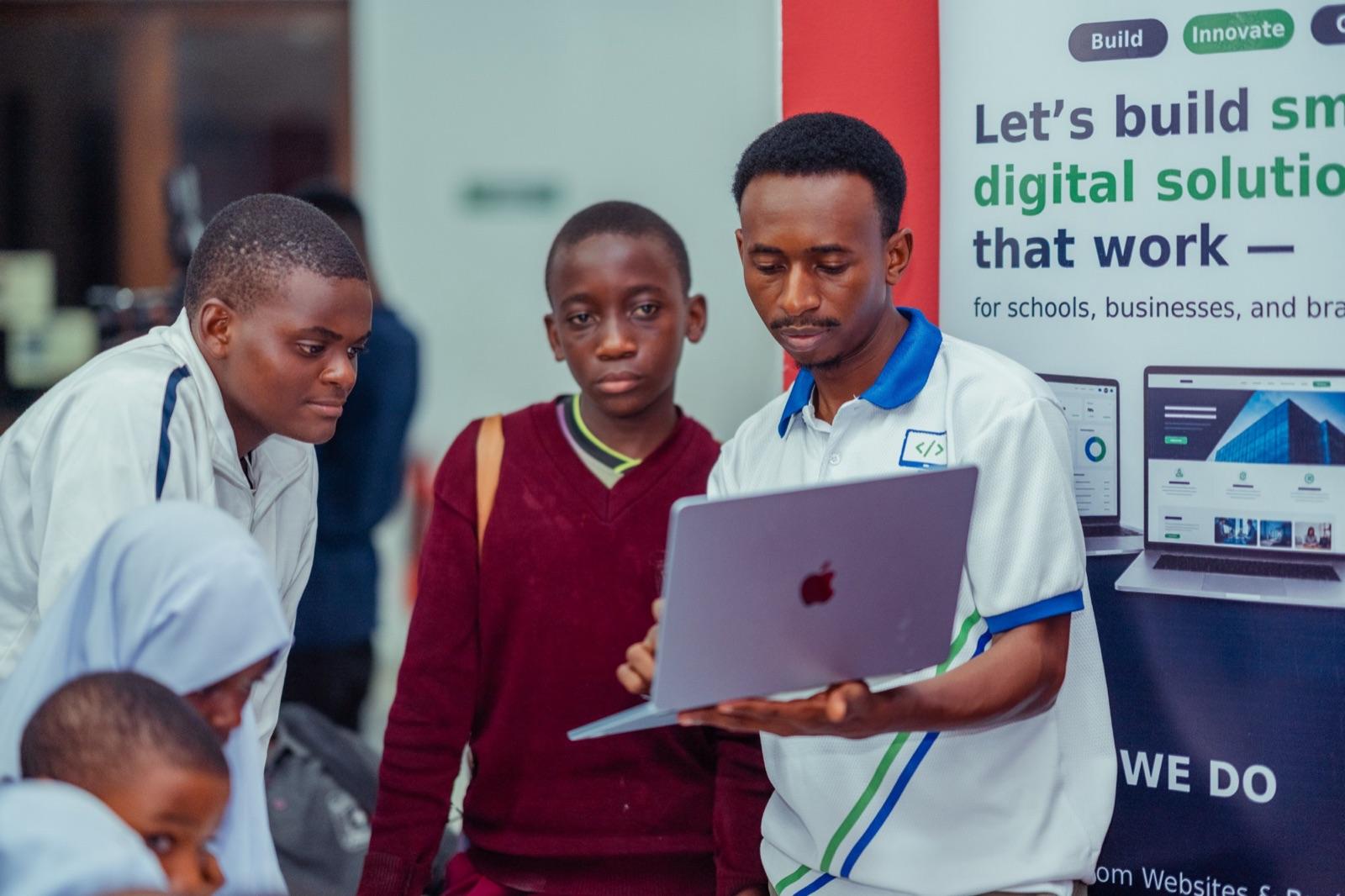 Simon Flavian showing students a project on a laptop